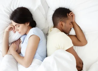 6 Ways To Save Your Marriage From Failing Husband and wife lying back to back in bed reflecting on relationship challenges