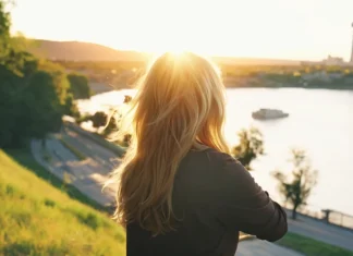 6 Amazing Ways To Change Your Life Woman admiring a golden sunset over the river reflecting on positive life transformation