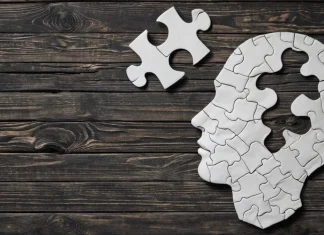 Most Effective Lessons You Can Learn From Yoda About Mental Toughness Paper head silhouette with puzzle piece on rustic wood symbolizing mental toughness and clarity