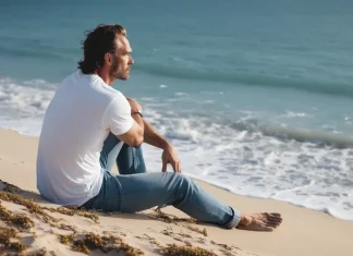 Signs Your Boyfriend Is Emotionally Unstable: What Psychologists Look For Man sitting alone thoughtfully on sandy beach shore overlooking ocean waves contemplating relationships