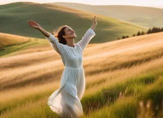 Fight Negative Energy Person standing in sunny mountain meadow with arms open releasing negative energy